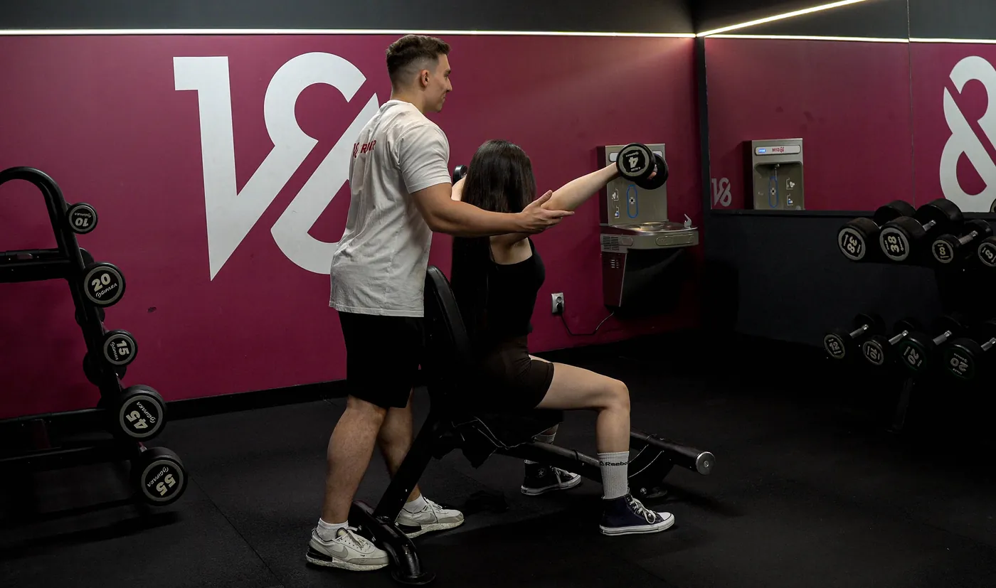 Antrenor personal corectând execuția unui exercițiu cu gantere, 18Gym Mărăști, Cluj-Napoca